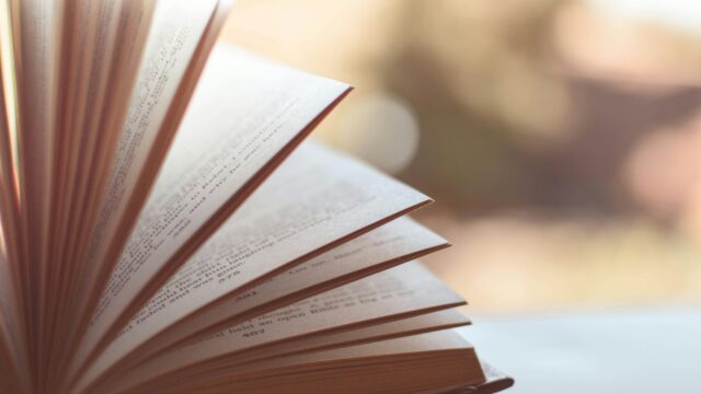 Book opened on white surface selective focus photography